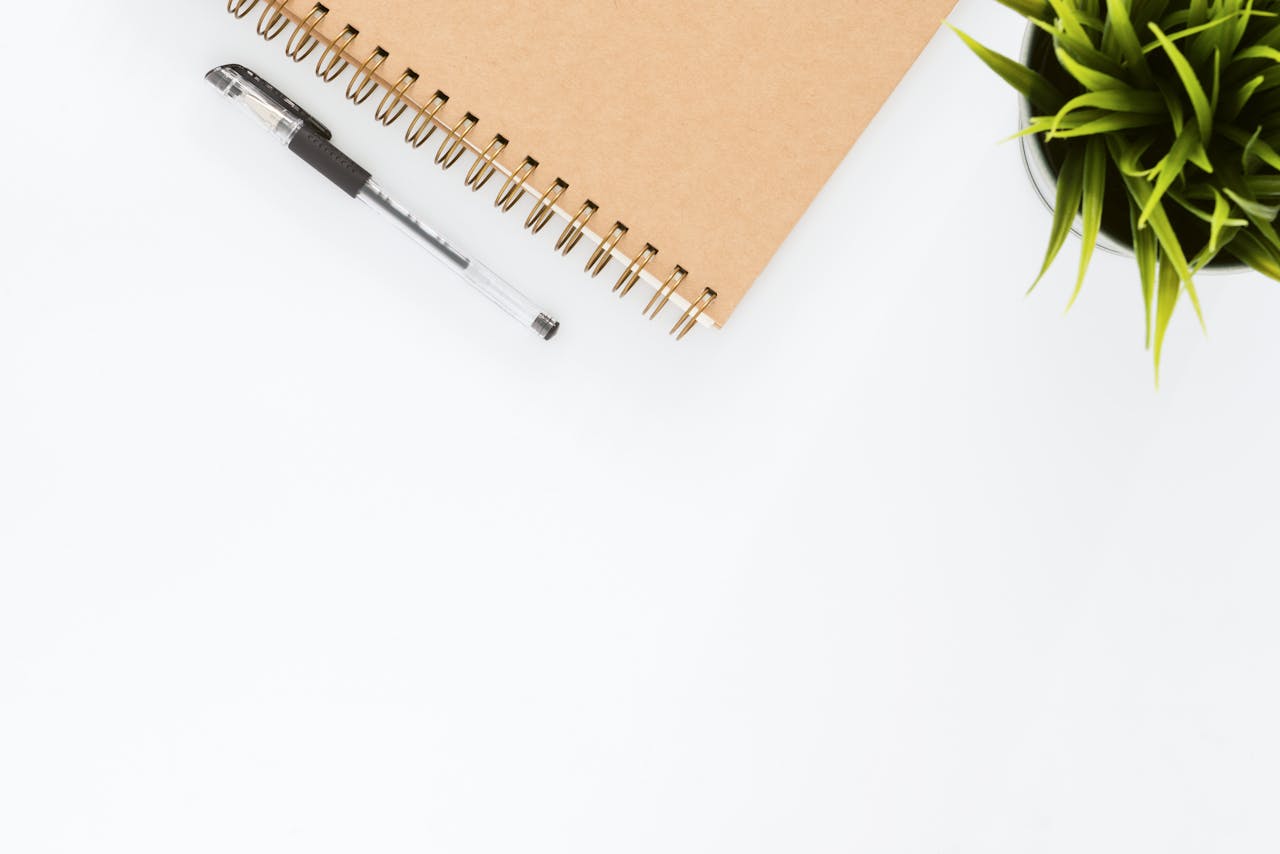 creative-03 Minimalist stationery setup with a spiral notebook and pen on a clean white desk.