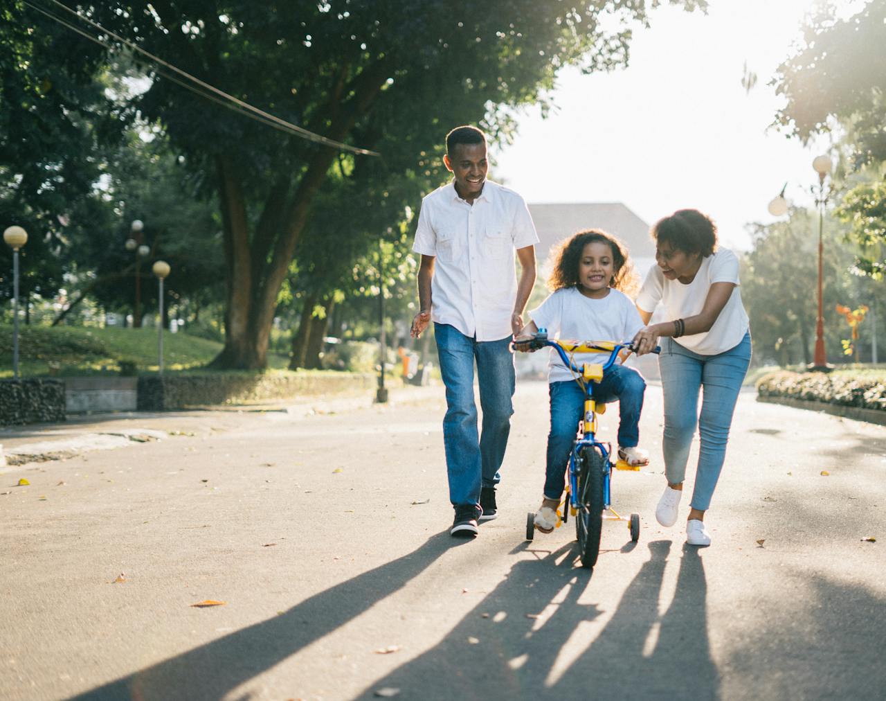 creative-02 Happy family teaching their child to cycle on a sunny day outdoors.